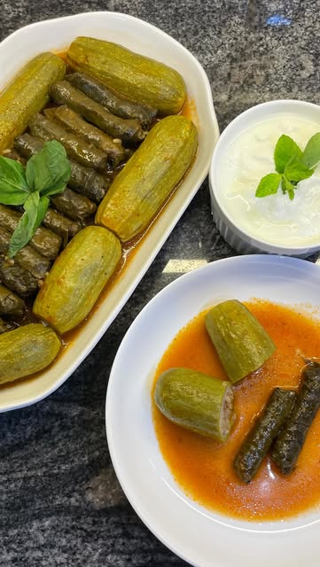 Stuffed zucchini and grape leaves with yogurt sauce